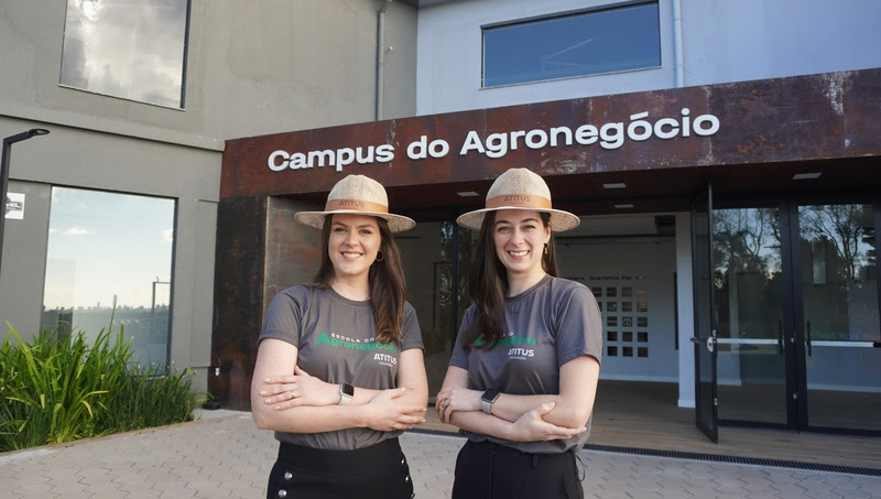 Duas mulheres, coordenadoras da Escola de Agronegócio Atitus, aparecem em frente a instituição