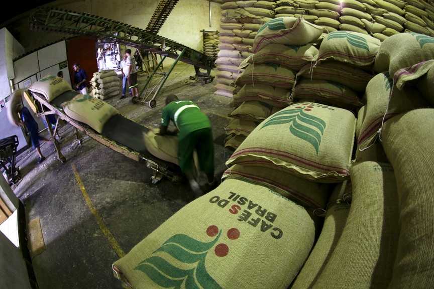 Em um galão, há pilhas de sacos com o texto "café do Brasil"